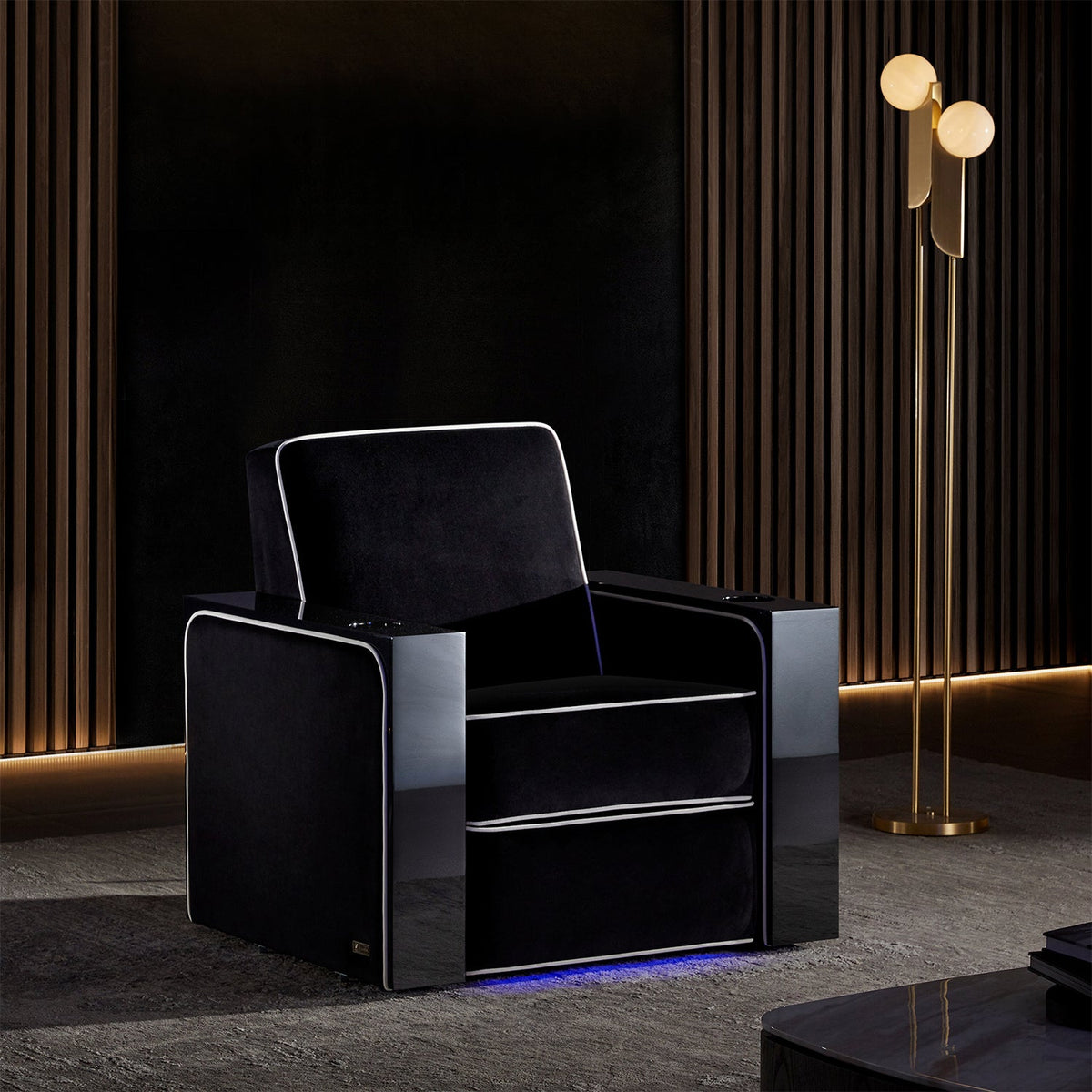 A single Valencia Naples Elegance Home Theater Chair in an upscale room with wood slates on the wall, a gold lamp, and a table